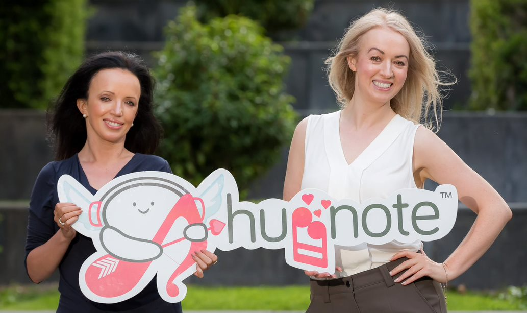 Huggnote founders Jacqui and Perry Meskell holding the Huggnote sign